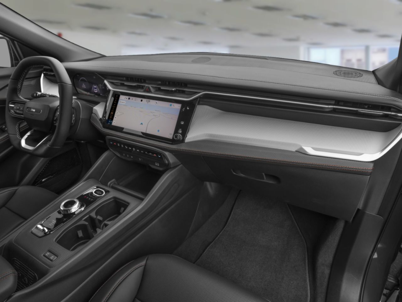 Habitacle moderne d’un Jeep Compass avec écran tactile central affichant la navigation, volant multifonction, console centrale avec sélecteur rotatif et intérieur noir au design épuré et technologique.